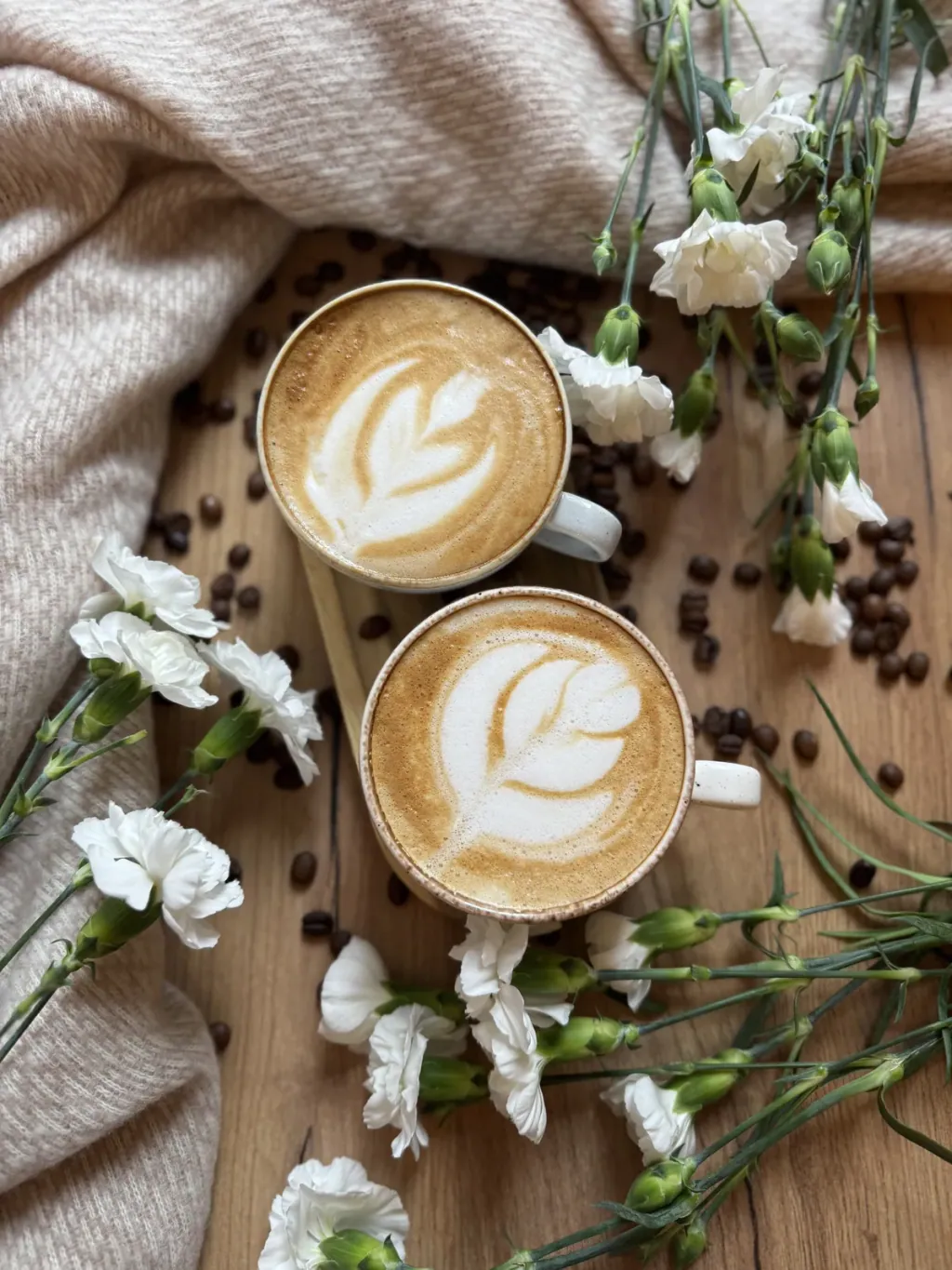Dwie filiżanki cappuccino z latte art widziane z góry