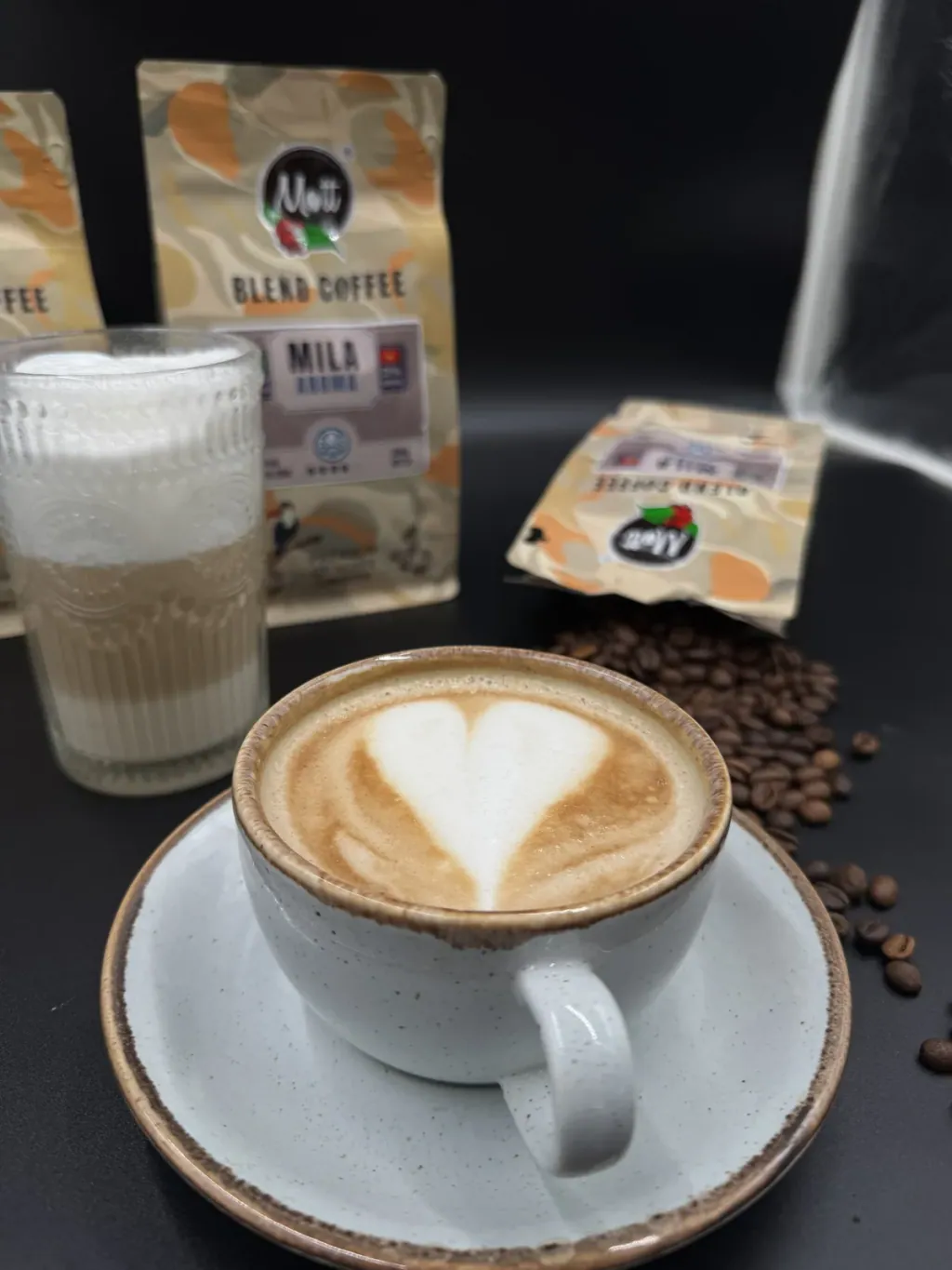 Latte z sercem w mlecznej piance obok opakowania kawy Mott Coffee