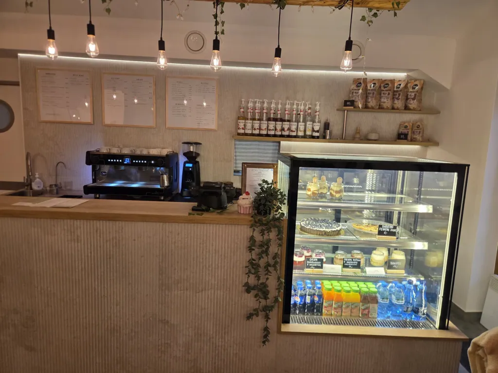 Bar kawowy z ekspresem i witryną z ciastami
